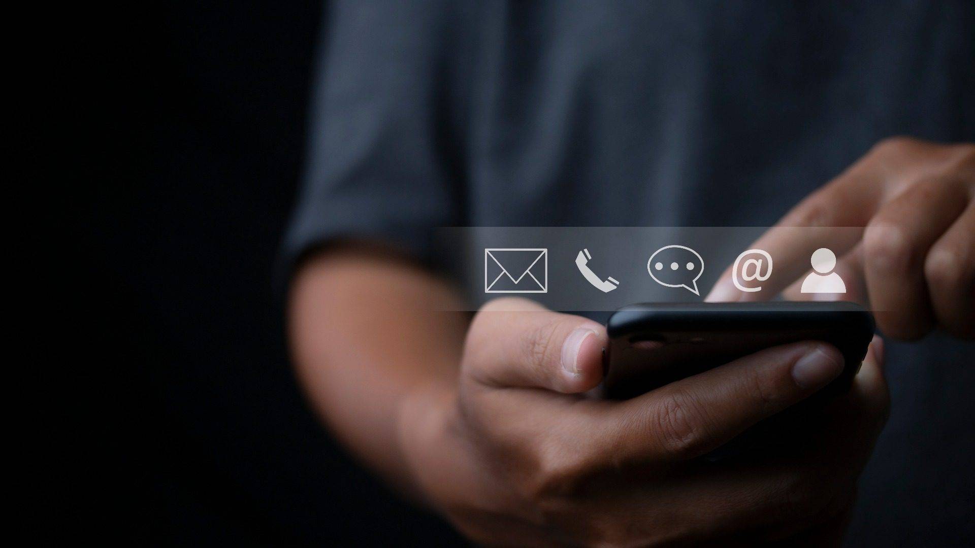 person holding a phone with contact icons